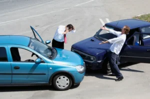 Two drivers standing outside their vehicles in frustration following a minor car collision.